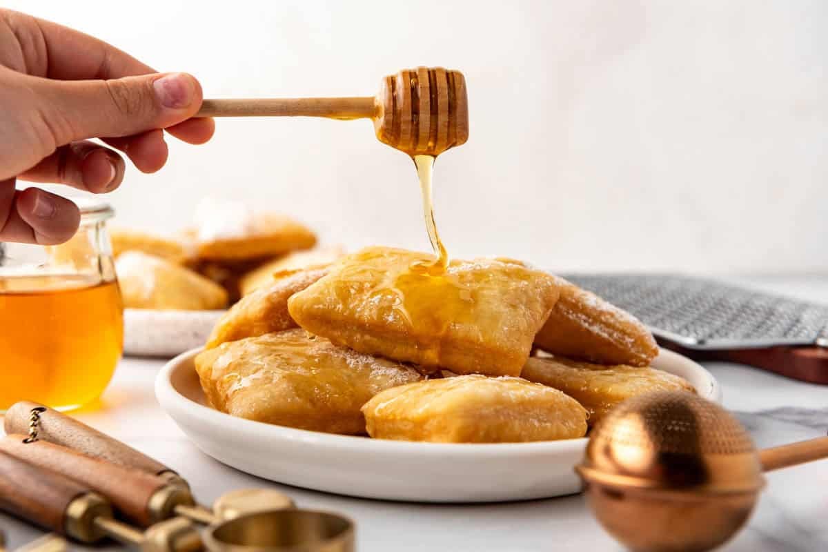 Honey being drizzled onto sopapillas.