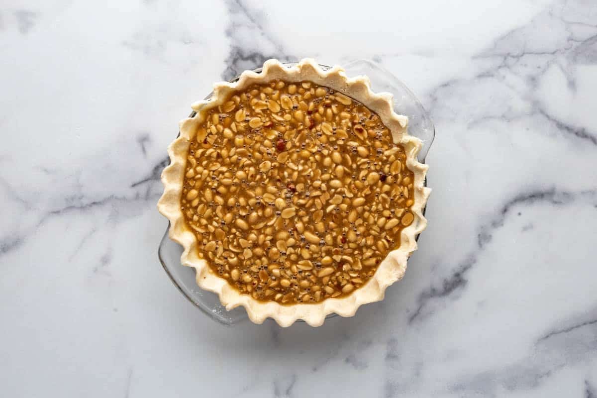 Peanut pie filling in an unbaked pie crust.