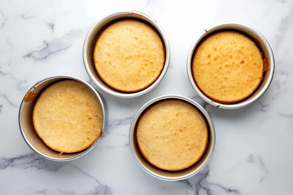 Baked cake layers in four pans.