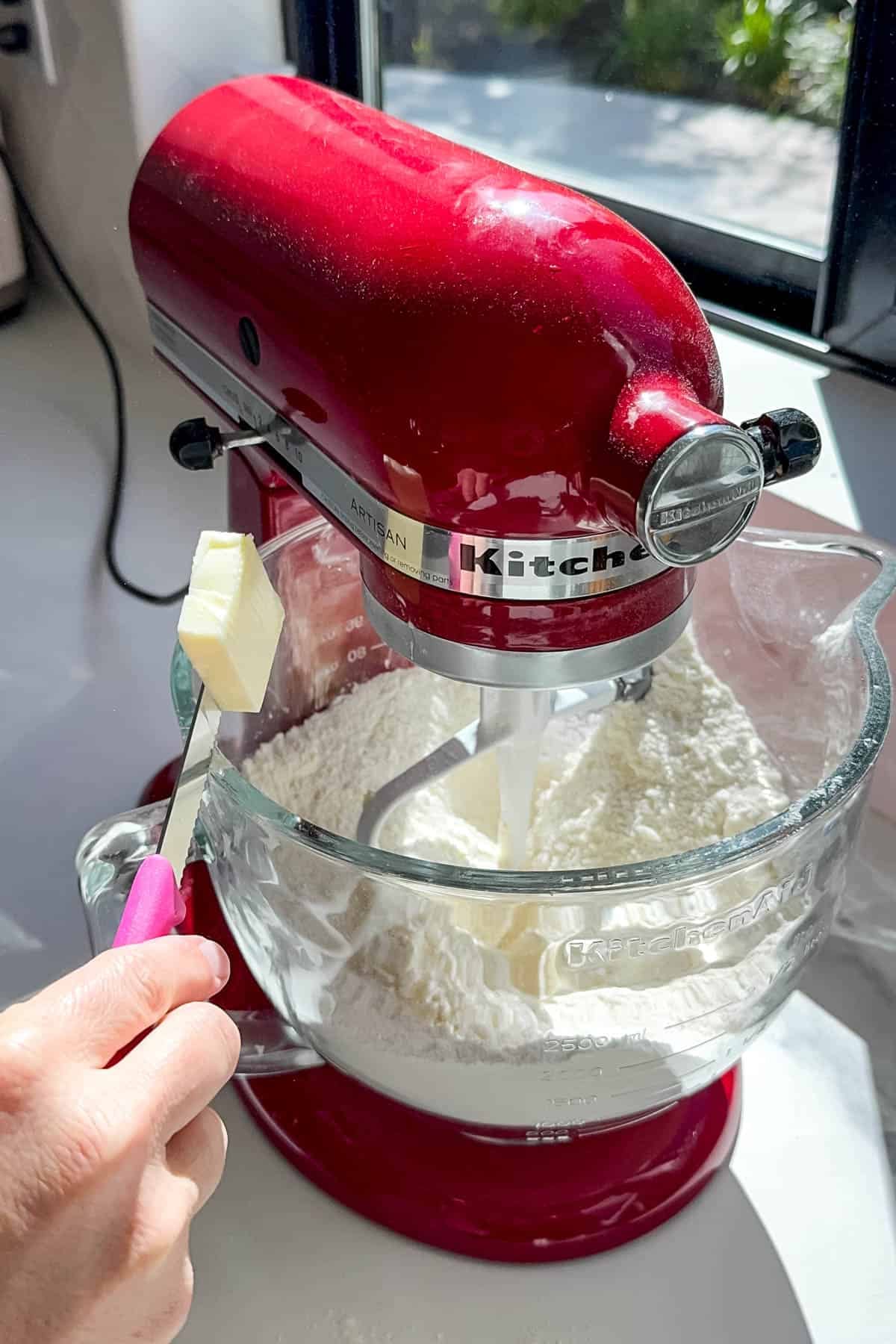 Adding softened butter to cake batter using the reverse creaming method.