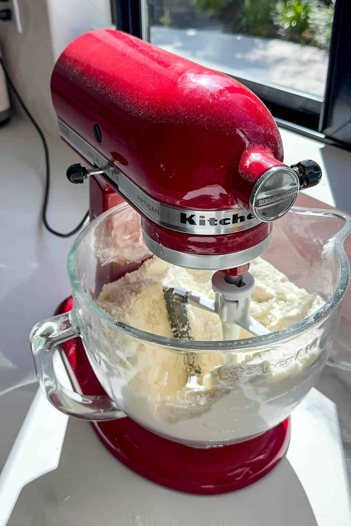 Adding whole milk to dry ingredients in a stand mixer.