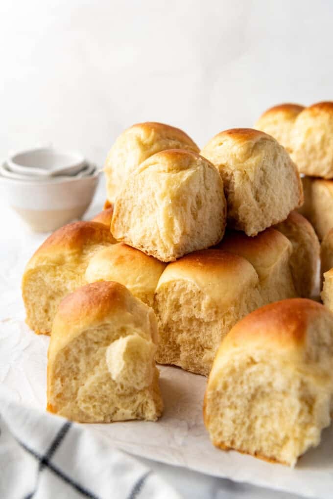 Stacked homemade Hawaiian rolls that have been torn apart and separated from each other.