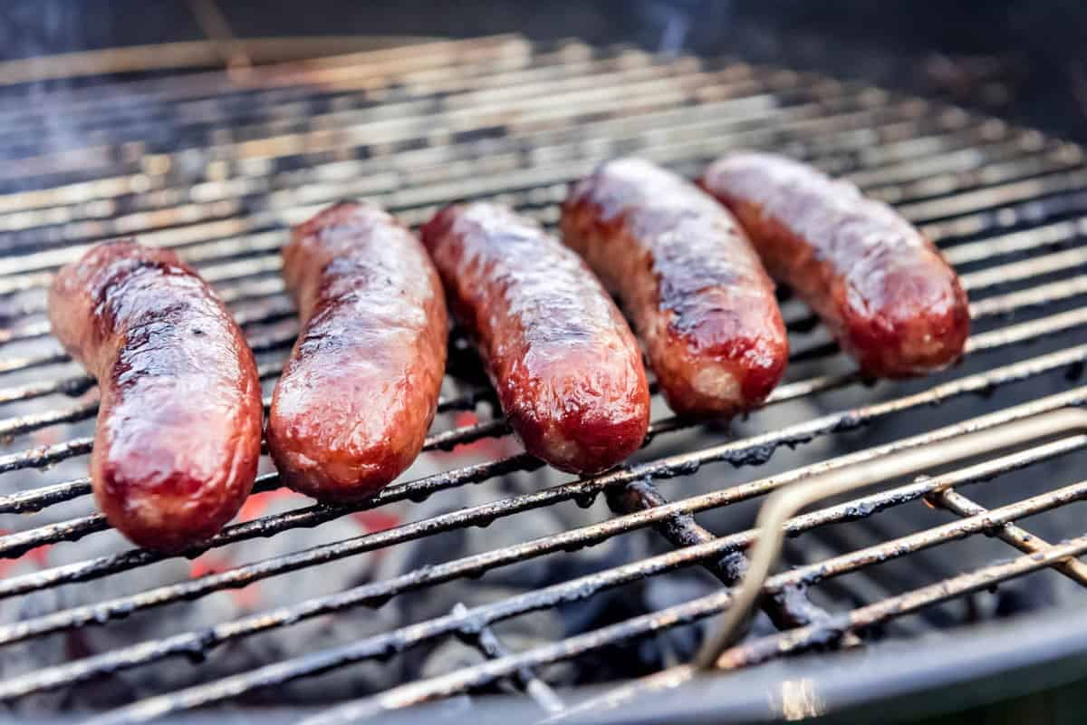 An image of brats on the grill.