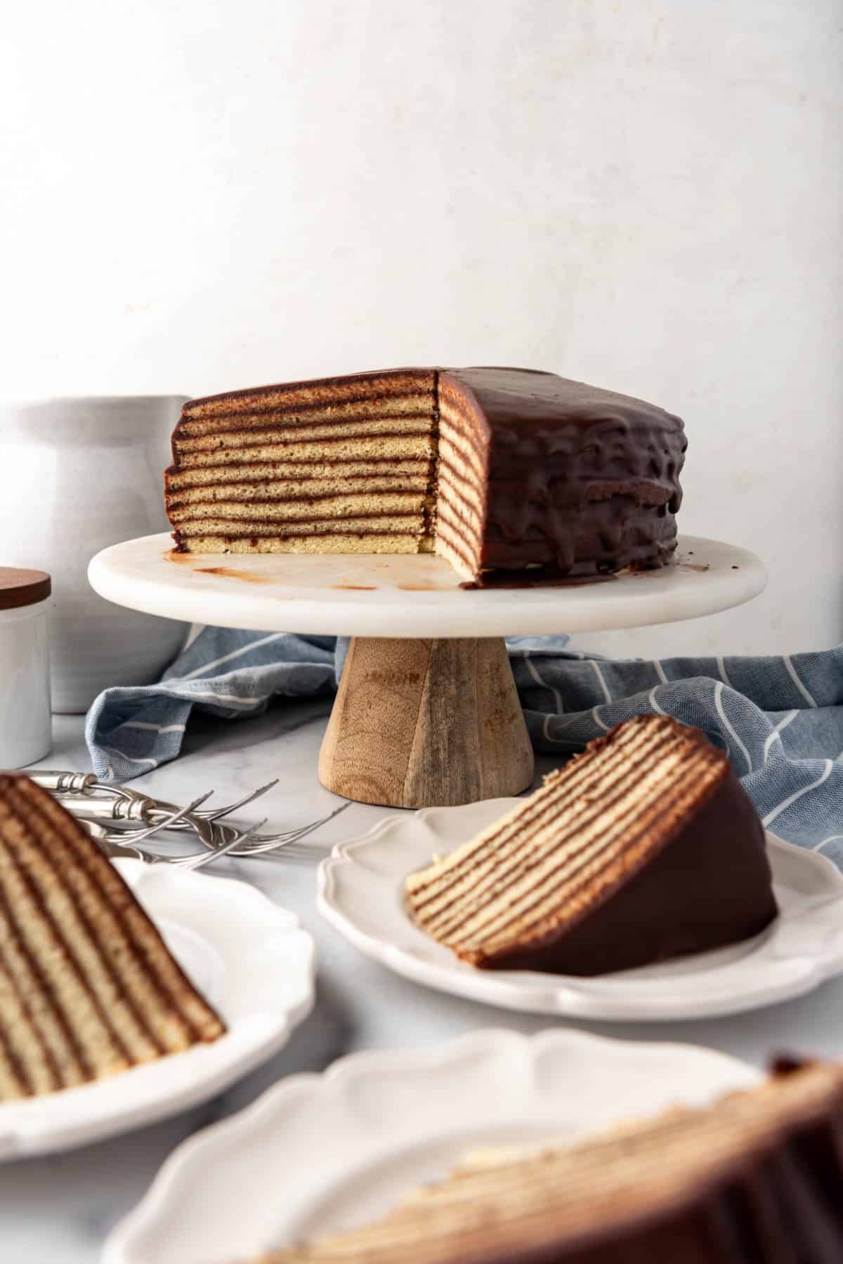 An image of a partially sliced Smith Island cake with slices on plates.