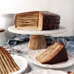 An image of a partially sliced Smith Island cake with slices on plates.
