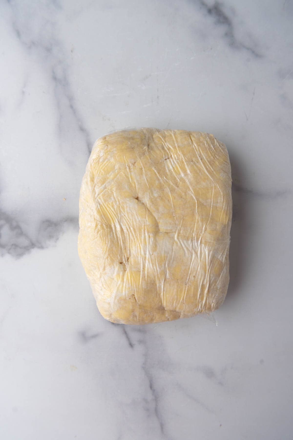 Kringle dough wrapped in plastic wrap to chill in the fridge.