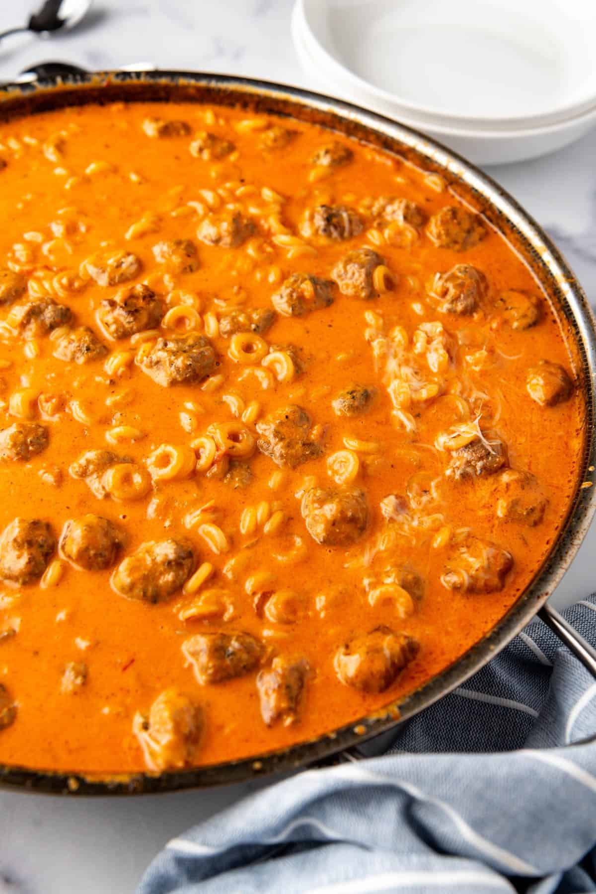 A side angle view of homemade spaghettios in a large skillet.