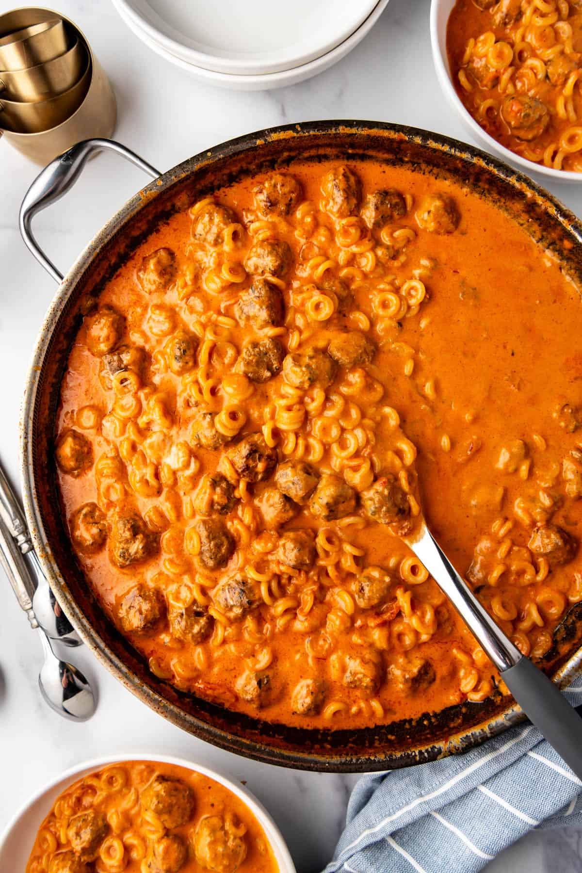 A large serving spoon in a pan of homemade spaghettios.