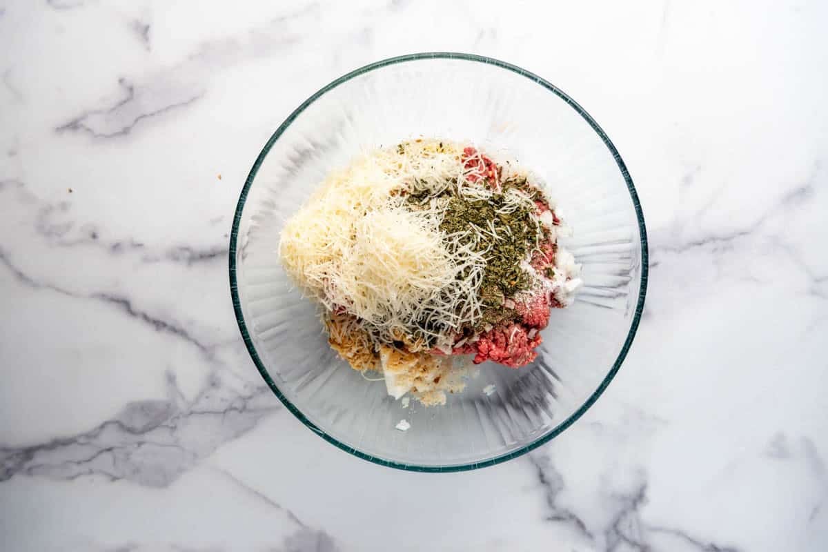 An image of ingredients for homemade meatballs in a bowl.