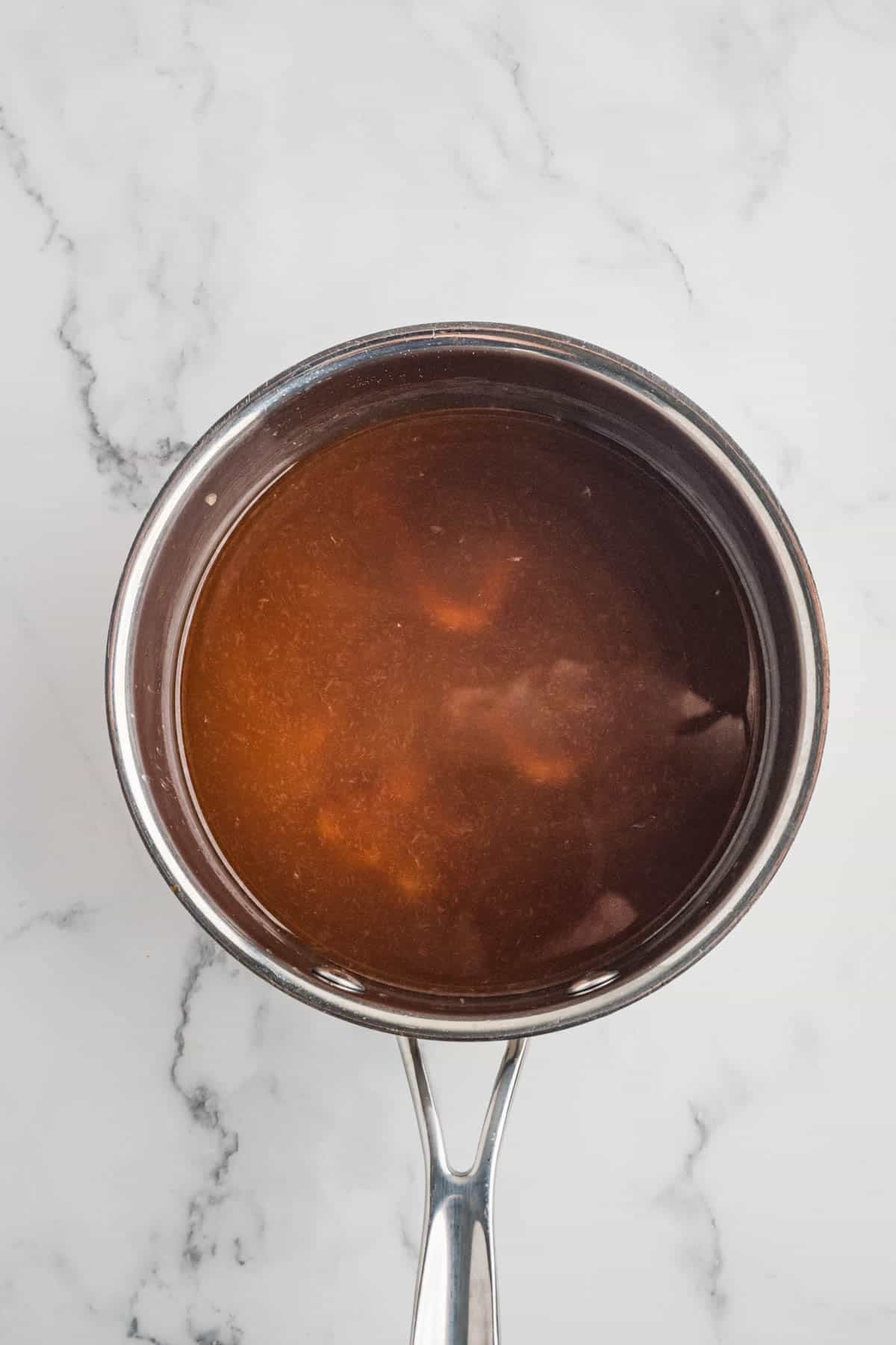 Combining ingredients in a saucepan to make homemade teriyaki sauce.