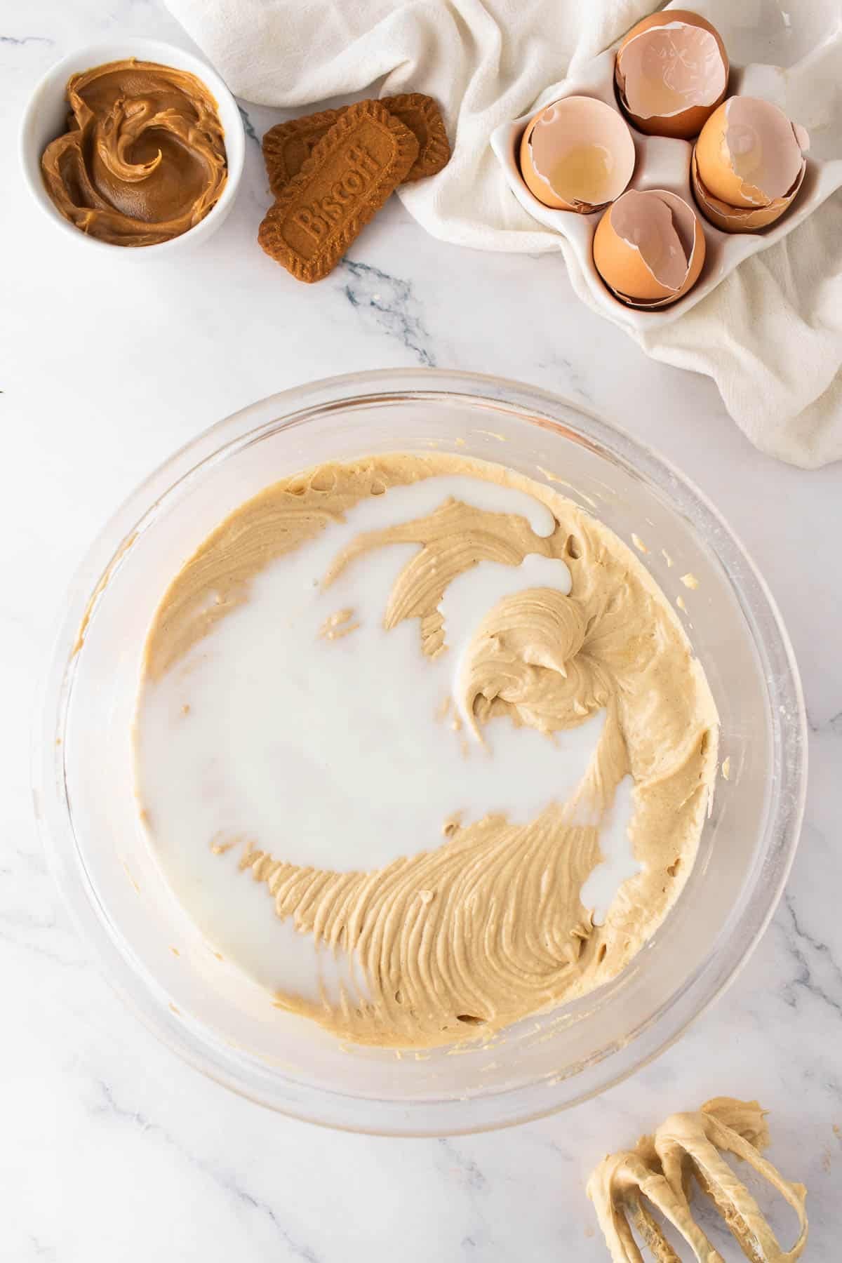 Adding milk to cake batter.