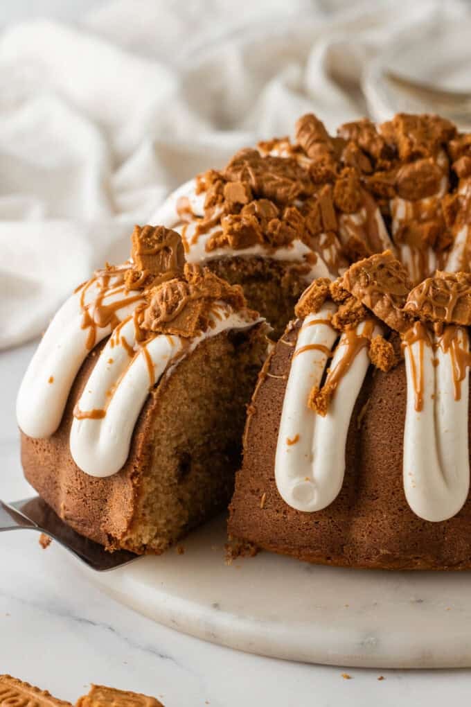 An overhead image of a slice of Biscoff cookie butter bundt cake being pulled out from the rest of the cake.