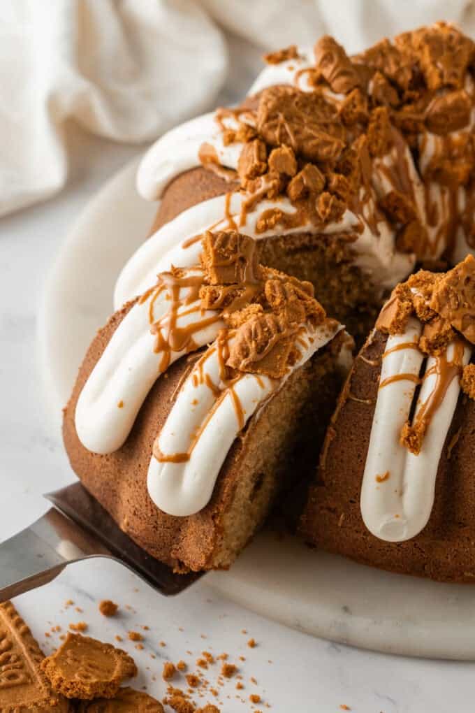 An overhead image of a slice of Biscoff cookie butter bundt cake being pulled out from the rest of the cake.