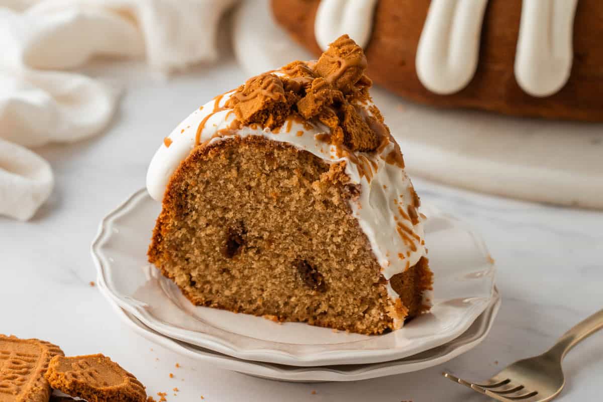 A slice of moist cookie butter bundt cake on a white plate.