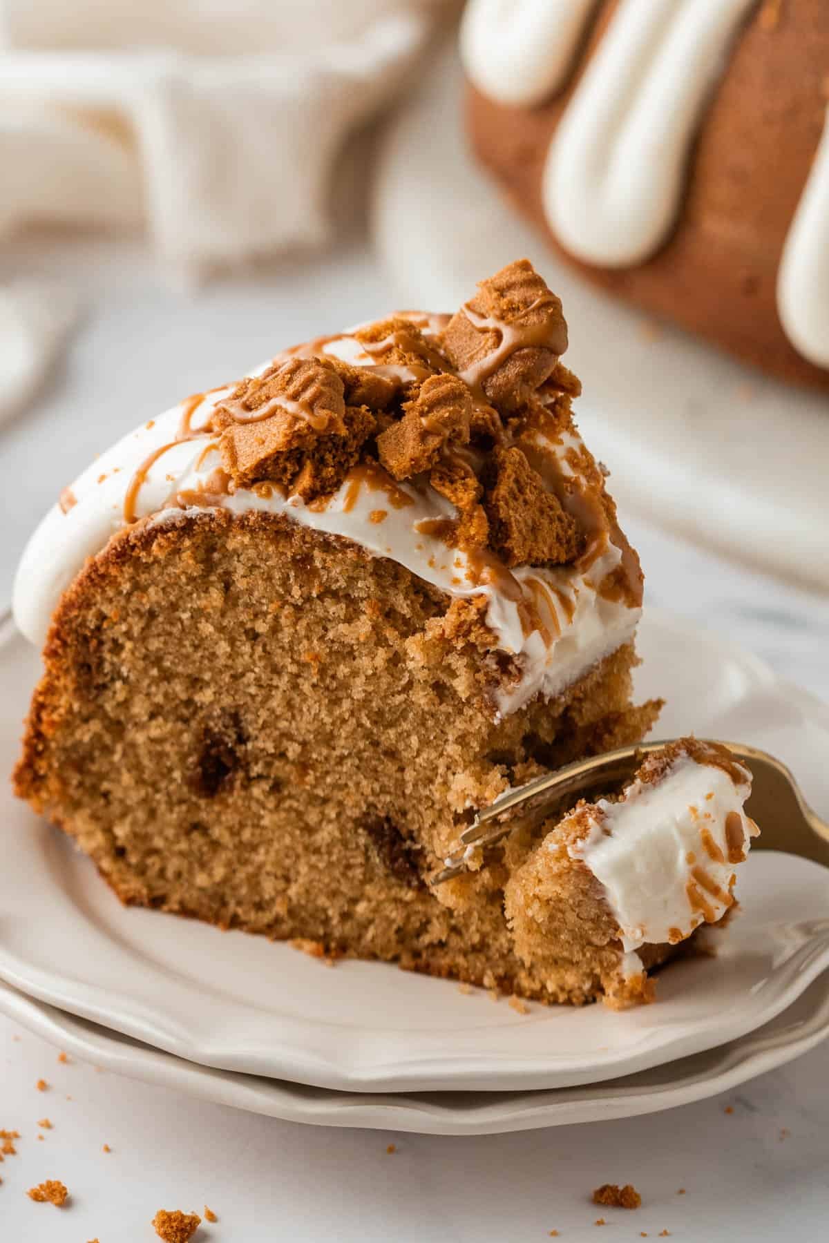 A bite being taken out of a slice of cake with a fork.