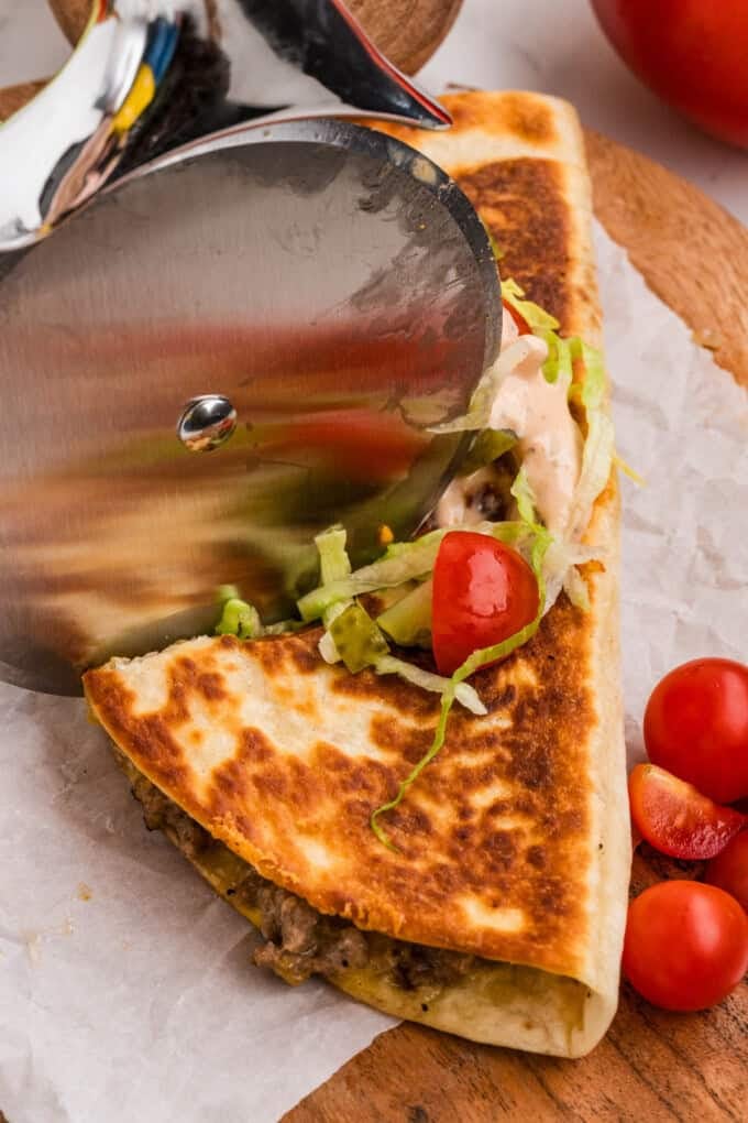 Using a pizza cutter to slice a quesadilla into triangles.