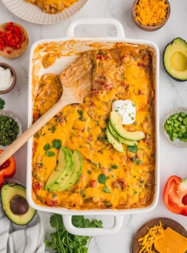 An overhead image of a pan of king ranch chicken with a wooden spoon in it.
