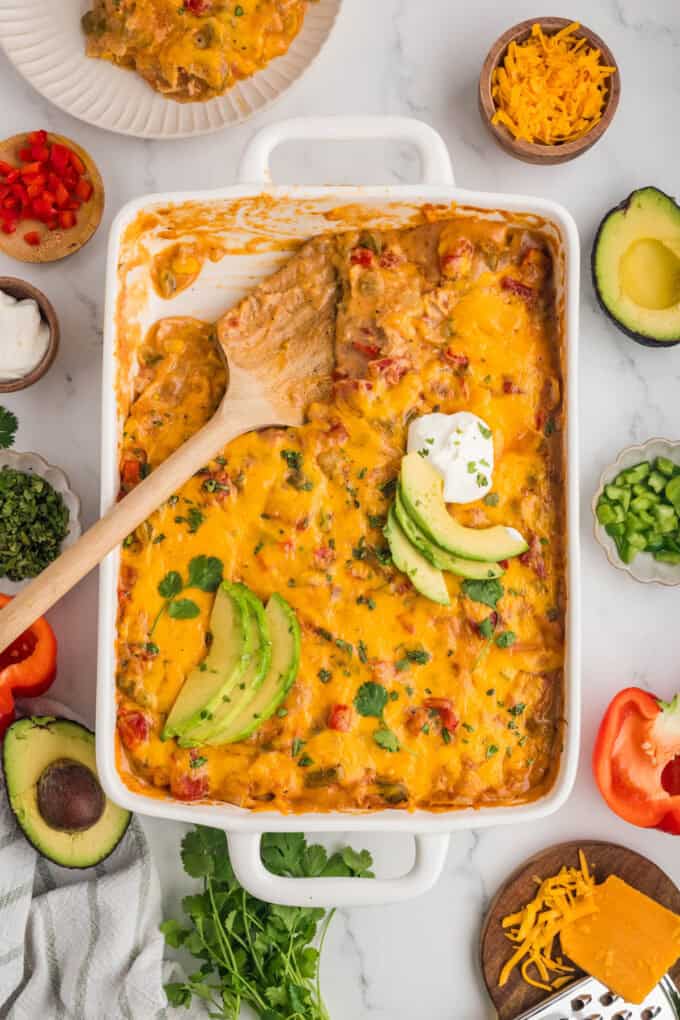 An overhead image of a pan of king ranch chicken with a wooden spoon in it.