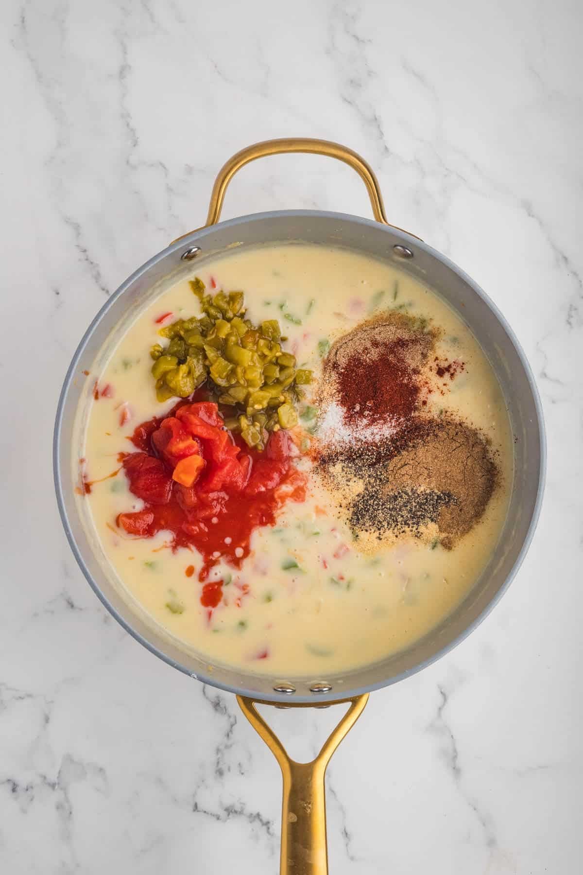 Spices in a pan with a creamy sauce.