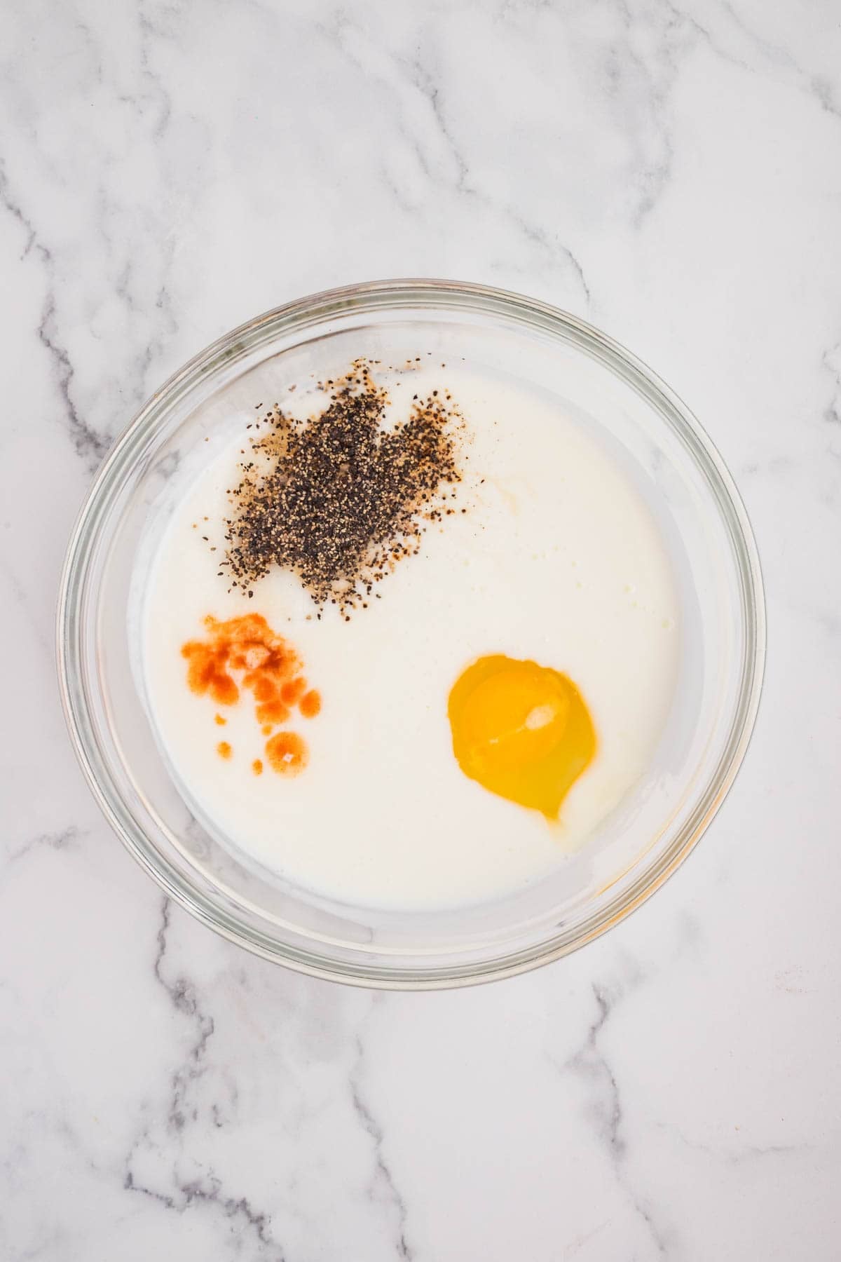 Buttermilk and spices in a bowl for marinating chicken.