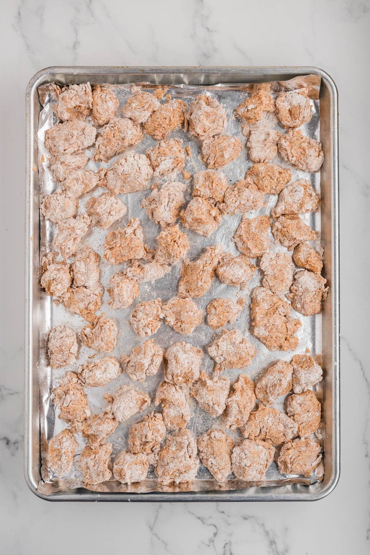 Chicken pieces coated in flour and spices.