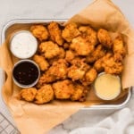 An image of homemade popcorn chicken with dipping sauces.