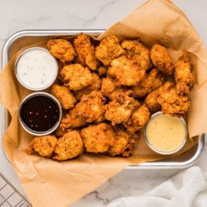 An image of homemade popcorn chicken with dipping sauces.
