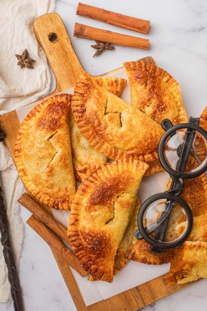 An overhead image of pumpkin pasites on a cutting board next to a pair of Harry Potter-style black glasses.
