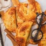 An overhead image of Harry Potter-inspired pumpkin pasties with a pair of black rimmed glasses next to them.
